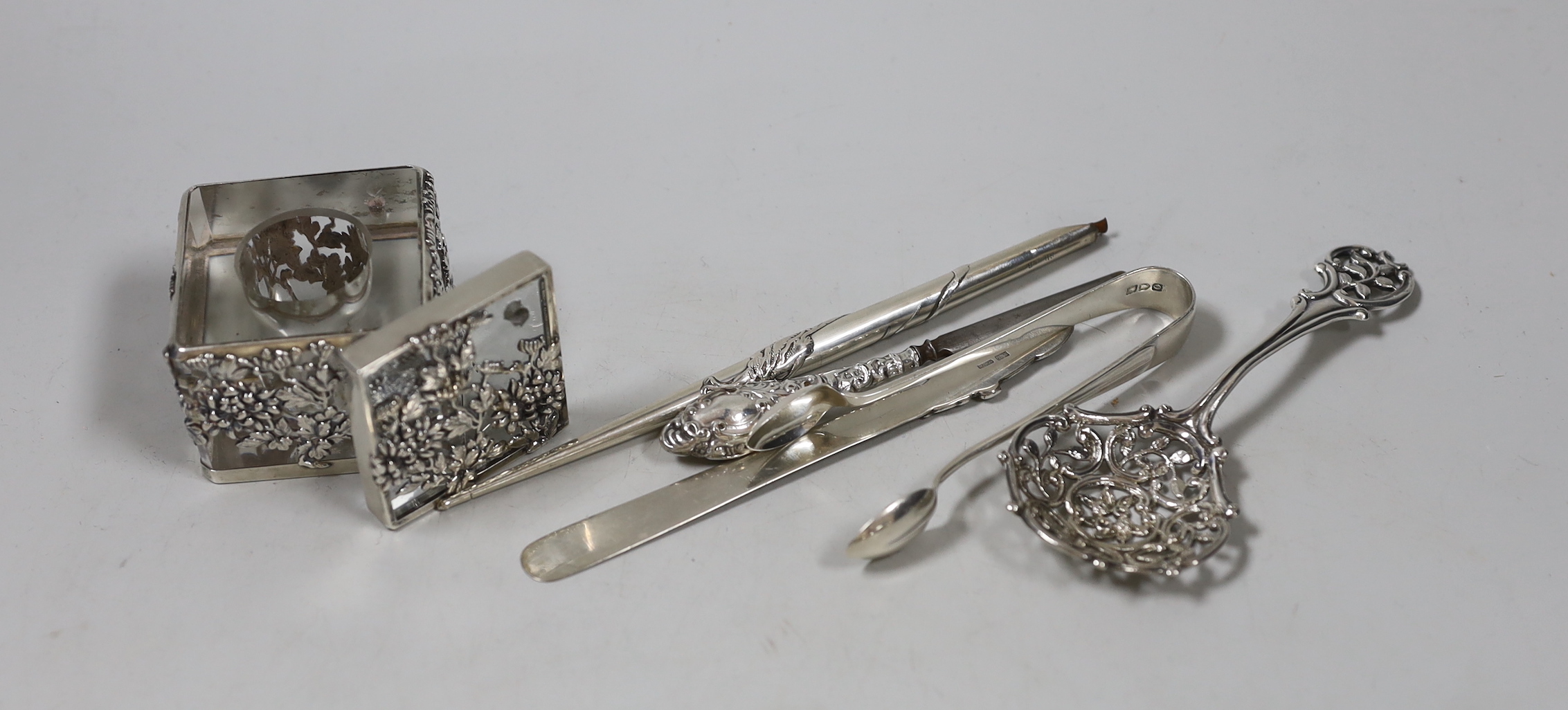 A late Victorian silver spoon, with pierced bowl and handle, Edward Hutton, London, 1893, 12.8cm, a Chinese white metal dip pen (stamped silver), a white metal mounted glass inkwell (stamped Risansha) and three other ite